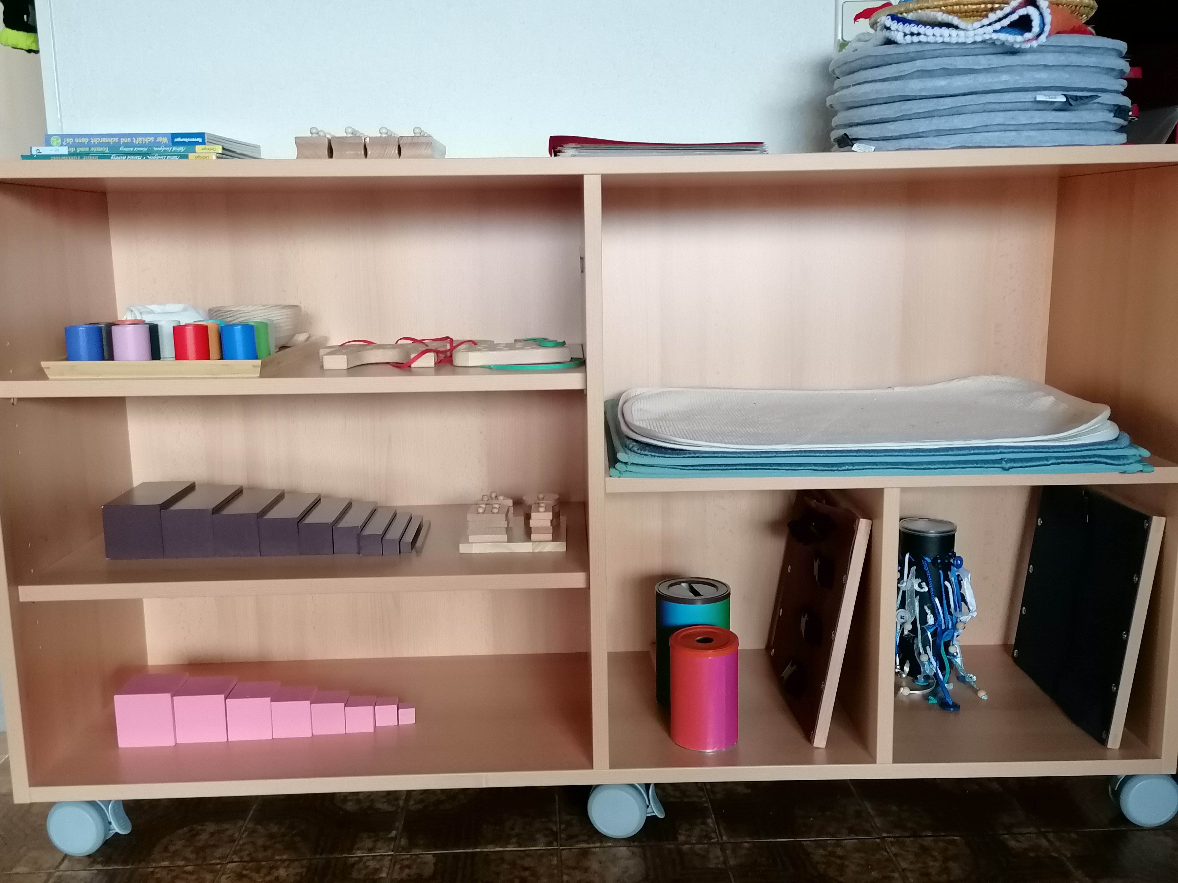 Tisch, auf dem Memory-Karten ausgebreitet liegen, darum herum sitzen vier Kinder, von denen nur die Hände zu sehen sind, und spielen Memory.